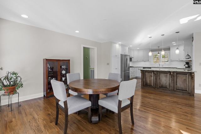 dining room featuring dark wood-type flooring, recessed lighting, and baseboards