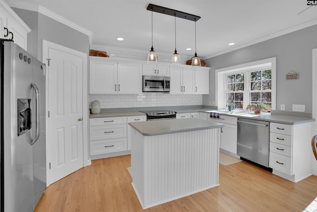 kitchen with decorative backsplash, appliances with stainless steel finishes, crown molding, and light wood-style floors