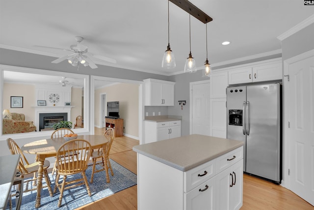 kitchen with a glass covered fireplace, stainless steel fridge, a ceiling fan, and ornamental molding