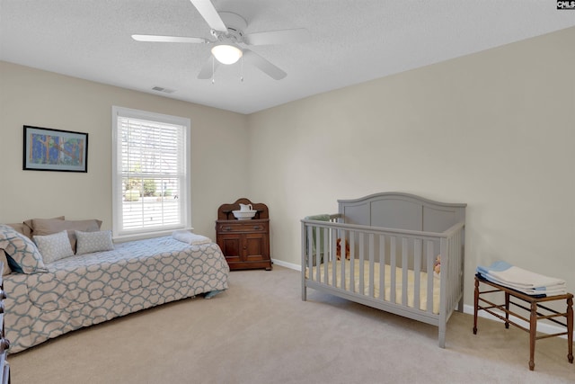 bedroom with visible vents, a textured ceiling, ceiling fan, and carpet flooring