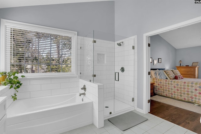 bathroom with connected bathroom, a shower stall, tile patterned flooring, a bath, and vaulted ceiling