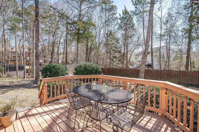 wooden deck with outdoor dining area, a storage shed, an outdoor structure, and fence