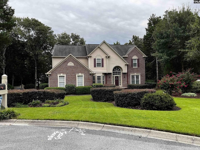 traditional-style home with brick siding and a front yard