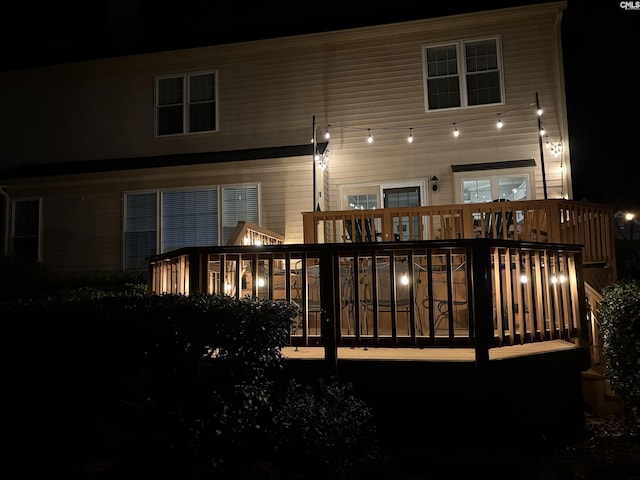 back of house at twilight with a deck