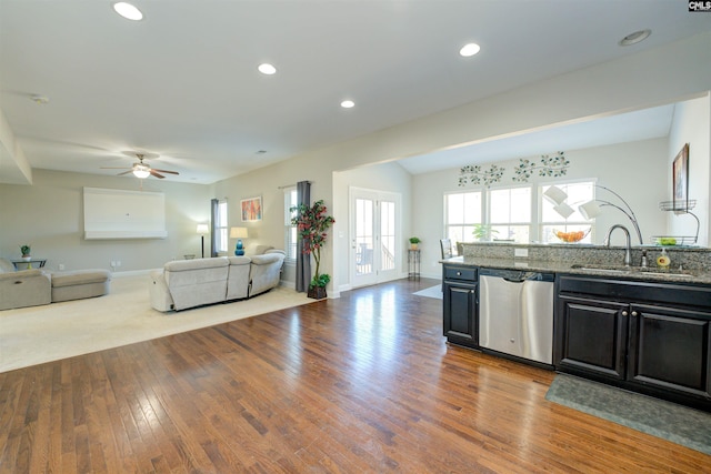 kitchen with hardwood / wood-style flooring, a sink, stainless steel dishwasher, open floor plan, and recessed lighting