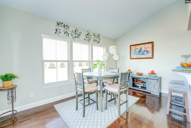 dining room featuring lofted ceiling, plenty of natural light, wood finished floors, and baseboards