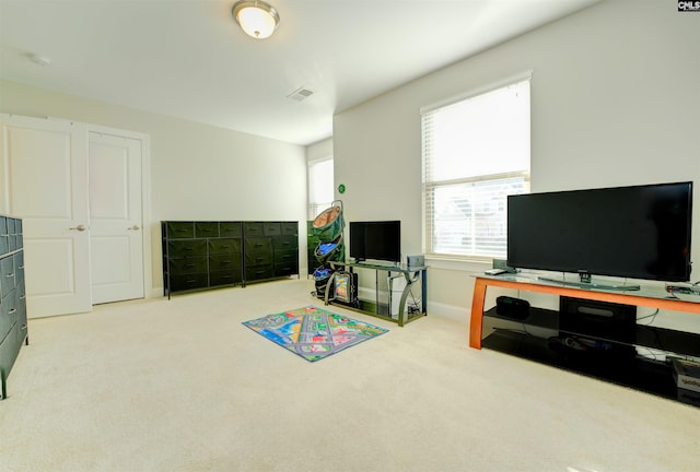 carpeted living area with baseboards and visible vents