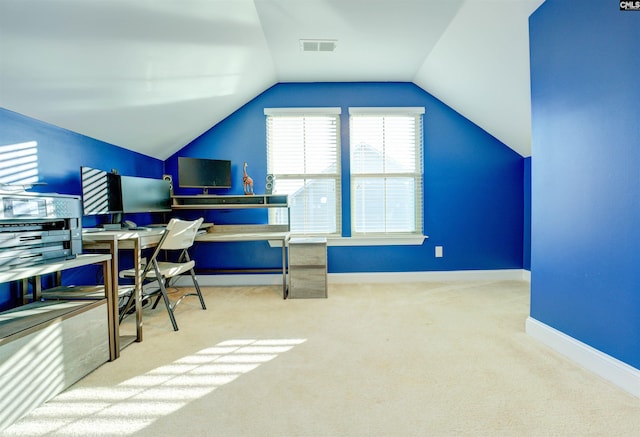 carpeted home office featuring vaulted ceiling, visible vents, and baseboards