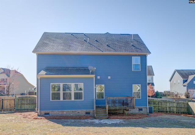 rear view of property featuring fence, roof with shingles, a wooden deck, a yard, and crawl space