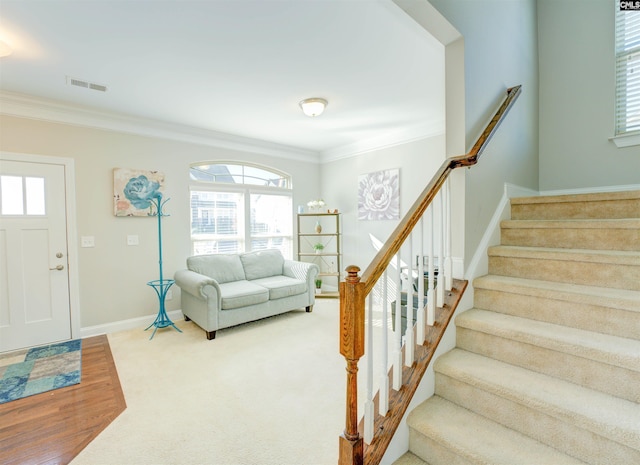 staircase featuring visible vents, carpet flooring, baseboards, and ornamental molding