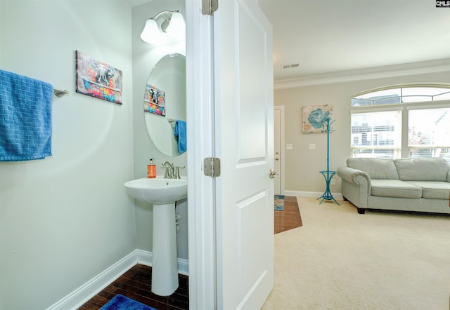 bathroom featuring visible vents, baseboards, and ornamental molding