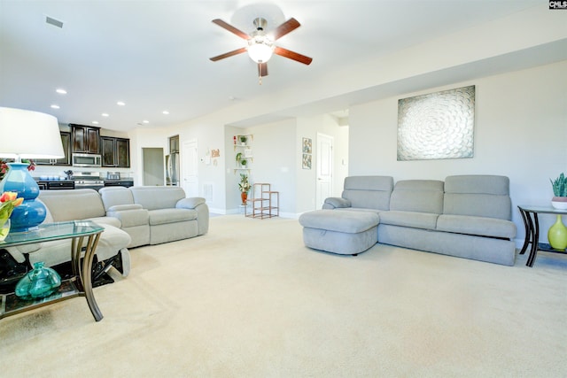 living area featuring visible vents, a ceiling fan, recessed lighting, baseboards, and light colored carpet