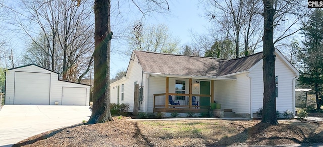 view of front facade with an outbuilding, driveway, roof with shingles, a porch, and a garage