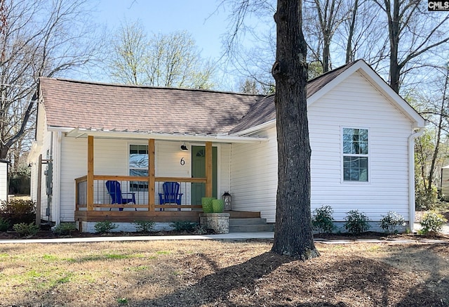 view of front of house featuring covered porch and a shingled roof