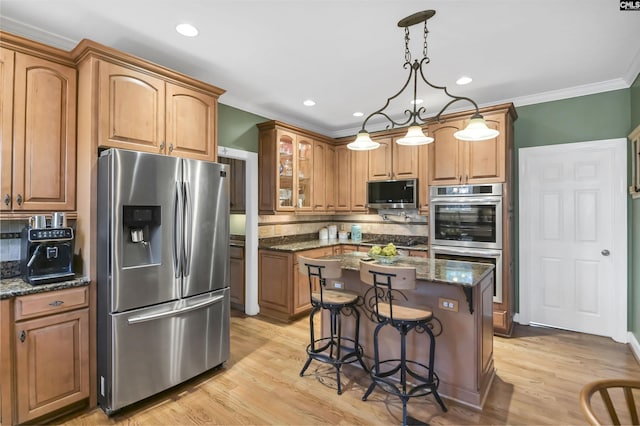 kitchen featuring backsplash, a kitchen island, a kitchen bar, dark stone countertops, and stainless steel appliances