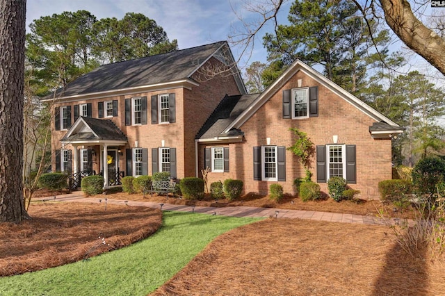 colonial inspired home featuring brick siding