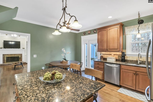 kitchen featuring a wealth of natural light, light wood-style flooring, ornamental molding, decorative backsplash, and dishwasher