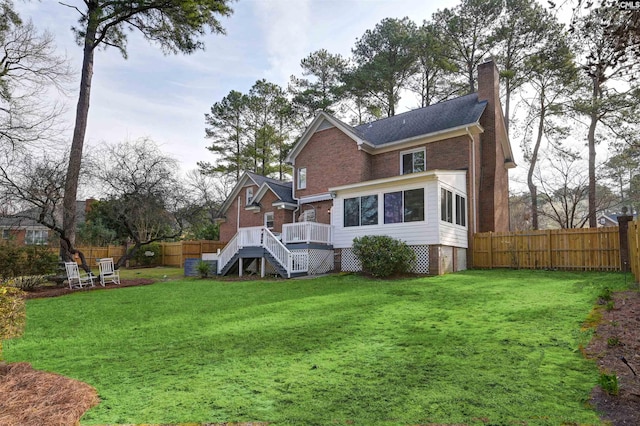 back of house featuring a fenced backyard, stairway, a chimney, and a yard