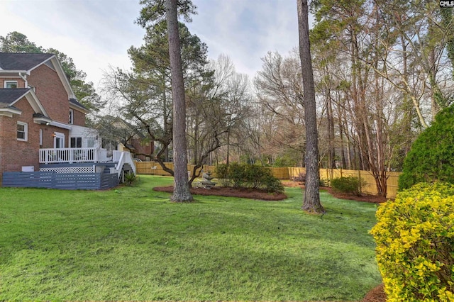 view of yard featuring a wooden deck and fence