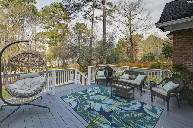 deck featuring outdoor lounge area and fence