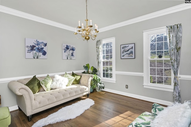 sitting room featuring baseboards, wood finished floors, a chandelier, and crown molding