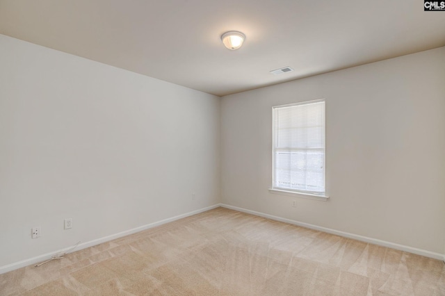 empty room with visible vents, light colored carpet, and baseboards