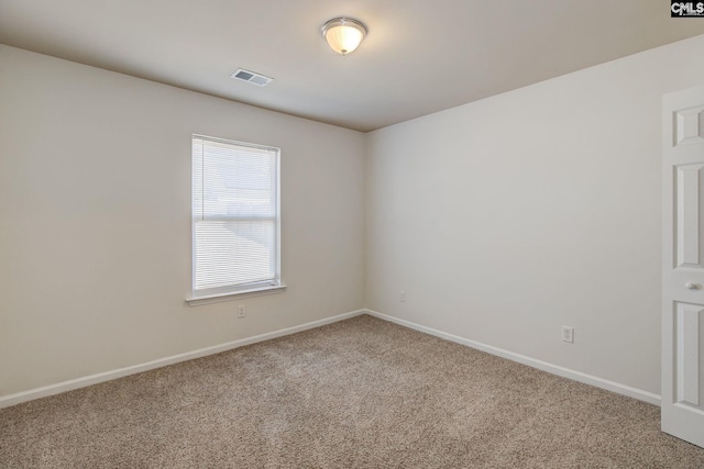 empty room with baseboards, visible vents, and carpet floors