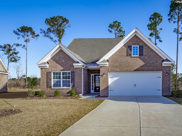 view of front of home featuring a garage, a front yard, brick siding, and driveway