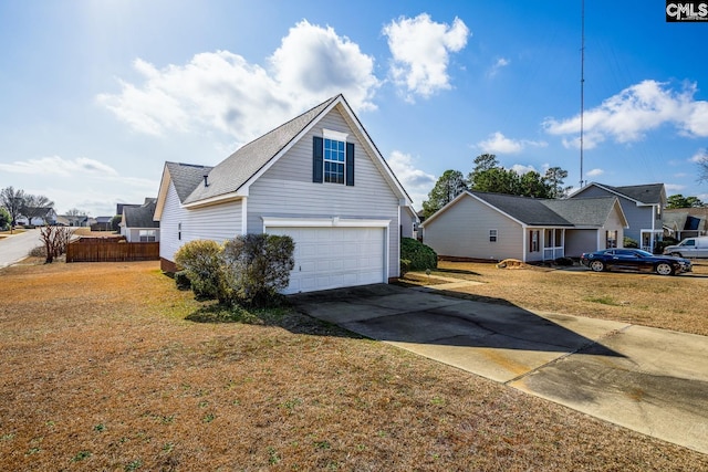 view of side of property with a lawn, an attached garage, and concrete driveway