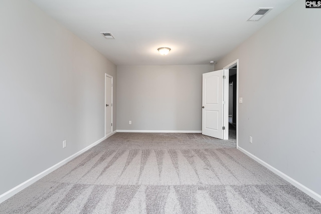 carpeted empty room with visible vents and baseboards