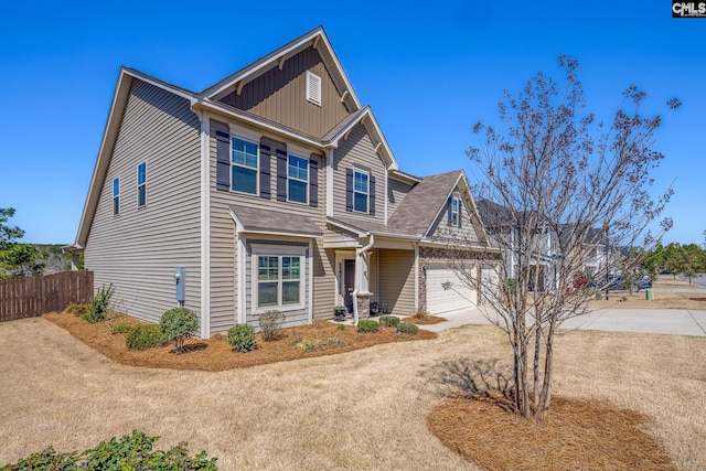 craftsman-style house with board and batten siding, driveway, and fence