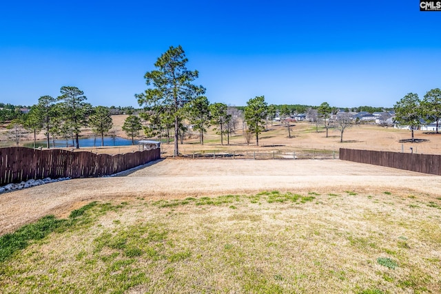 view of yard featuring a water view and fence