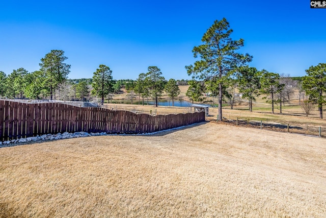 view of yard with a water view and fence