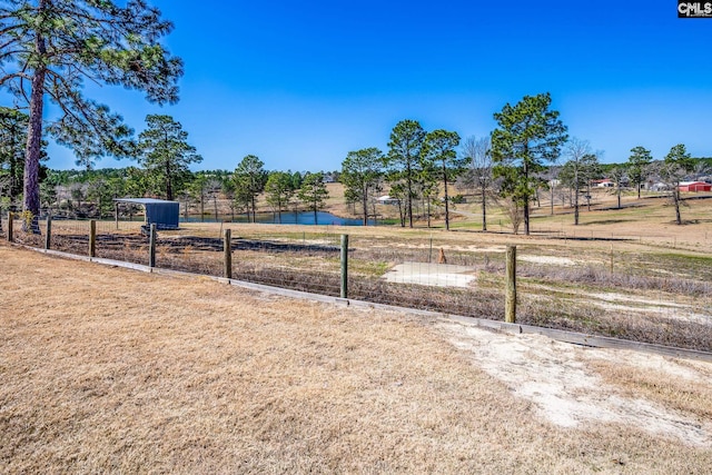 surrounding community with fence and a water view