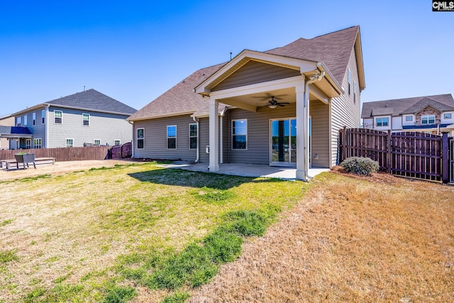 rear view of house featuring a patio, a lawn, a fenced backyard, and a ceiling fan