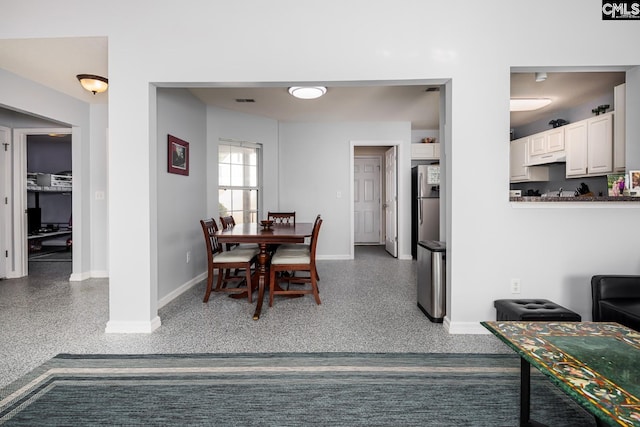 dining space featuring visible vents, speckled floor, and baseboards