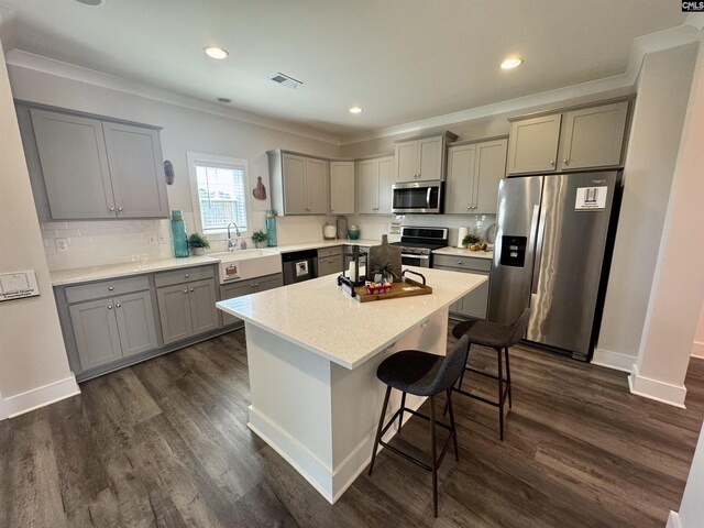 kitchen with a breakfast bar, visible vents, gray cabinetry, and stainless steel appliances