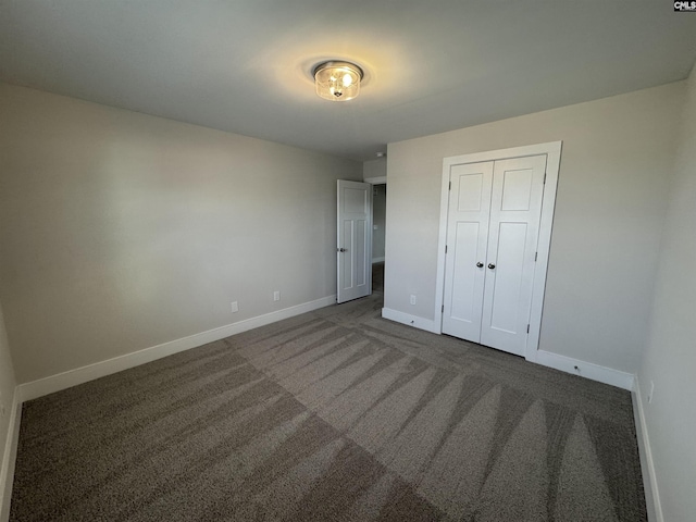 unfurnished bedroom featuring a closet, carpet flooring, and baseboards