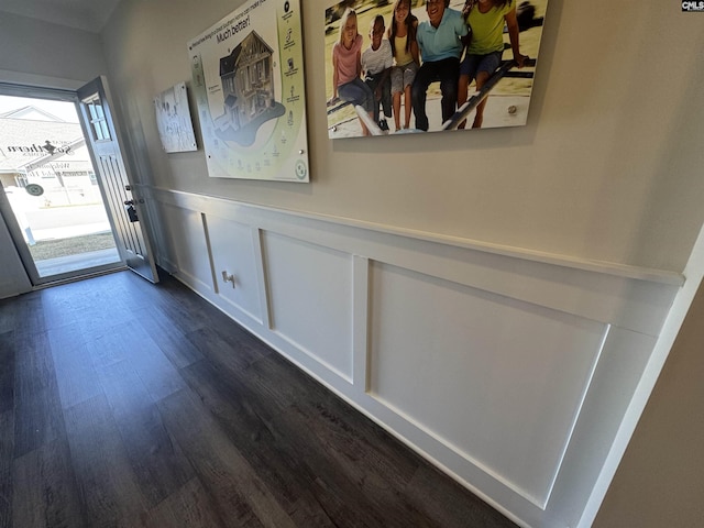 entryway with a decorative wall, wainscoting, and dark wood-style flooring