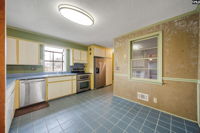 kitchen featuring under cabinet range hood, stainless steel appliances, visible vents, and crown molding