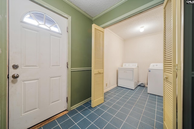 laundry area with washer and clothes dryer, dark tile patterned floors, ornamental molding, laundry area, and a textured ceiling