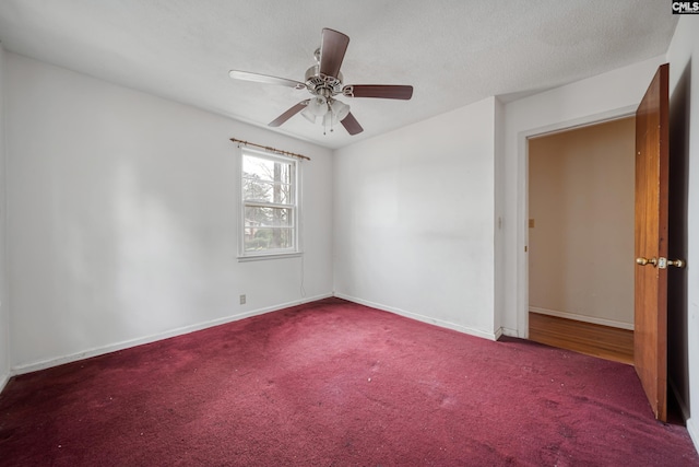 empty room featuring baseboards, a textured ceiling, carpet floors, and ceiling fan