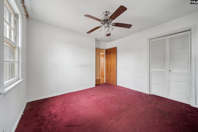 unfurnished bedroom with carpet flooring, multiple windows, baseboards, and a closet