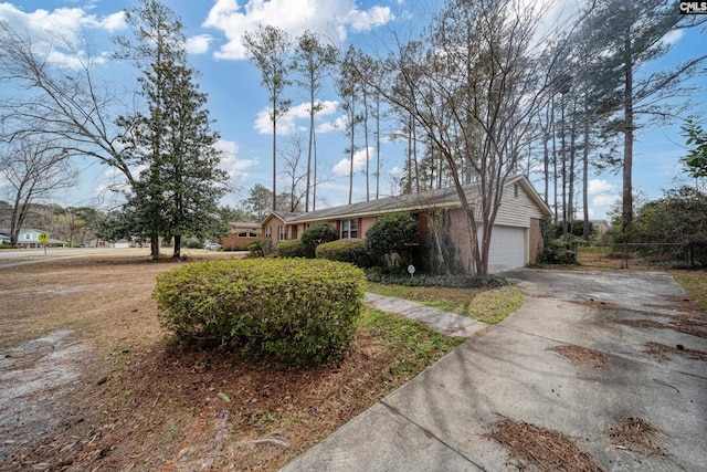 ranch-style house with an attached garage, fence, brick siding, and driveway