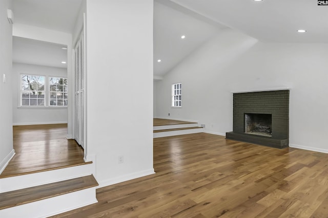 unfurnished living room featuring a fireplace, baseboards, and wood finished floors