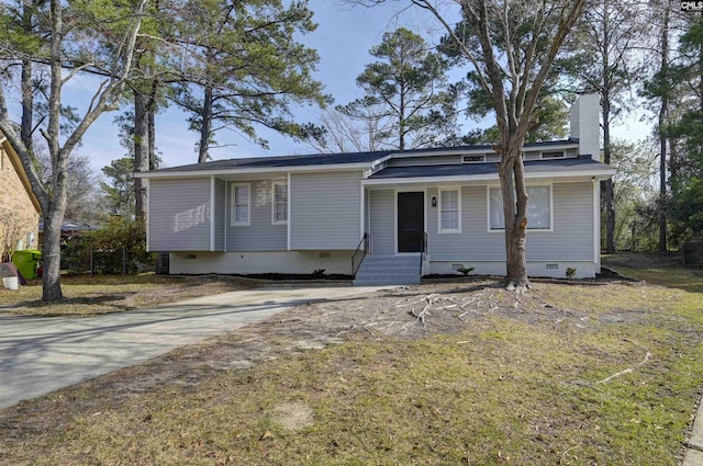 view of front facade featuring crawl space, concrete driveway, and a chimney