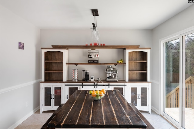 unfurnished dining area featuring light tile patterned flooring and baseboards