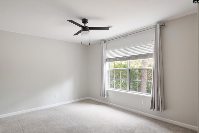 empty room with baseboards, light colored carpet, and a ceiling fan