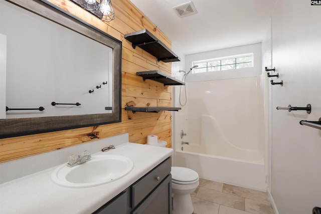 bathroom with wooden walls, toilet, vanity, and visible vents