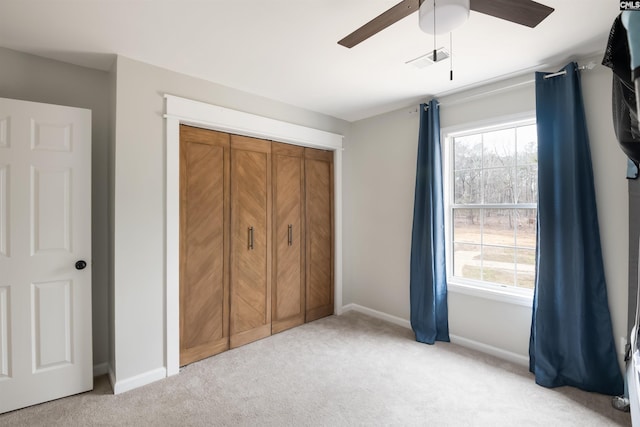 unfurnished bedroom featuring baseboards, multiple windows, and light colored carpet